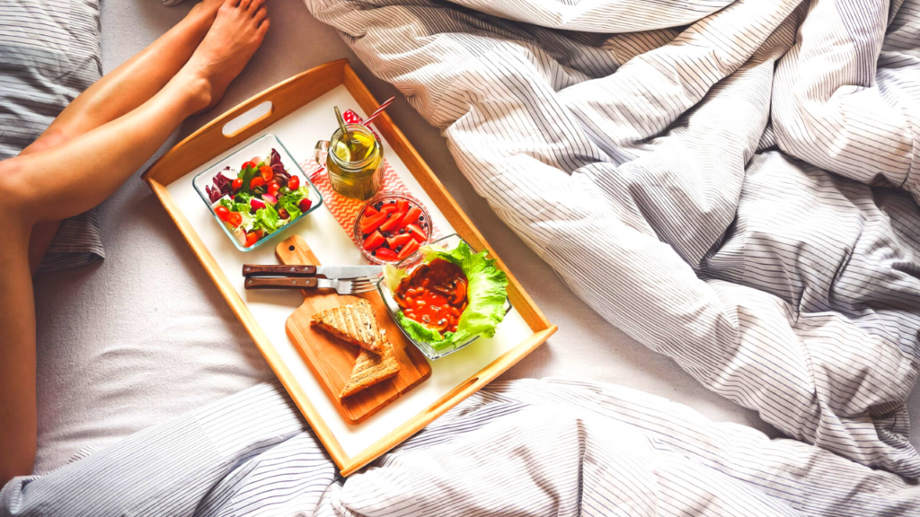a girl in a bed with a tray of food - vegans sleep better